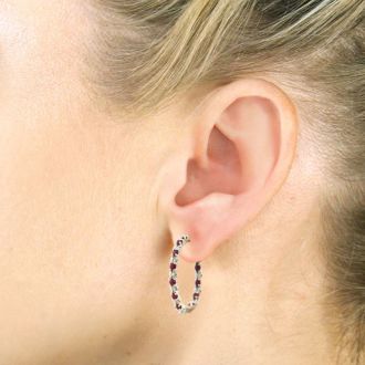 Hoop earrings will always be in style!  Be sure to grab these fabulous ruby and diamond hoop earrings.  Each earring has 12 ruby stones and are set in sterling silver.  Dangling at about 1 inches down, they are perfect for everyone.  Total gem weight is 1.5 carats.  Diamond content is .01 carats, diamond color is J-K and diamond clarity is I2-I3.