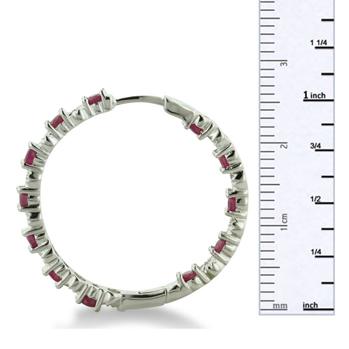 Hoop earrings will always be in style!  Be sure to grab these fabulous ruby and diamond hoop earrings.  Each earring has 12 ruby stones and are set in sterling silver.  Dangling at about 1 inches down, they are perfect for everyone.  Total gem weight is 1.5 carats.  Diamond content is .01 carats, diamond color is J-K and diamond clarity is I2-I3.