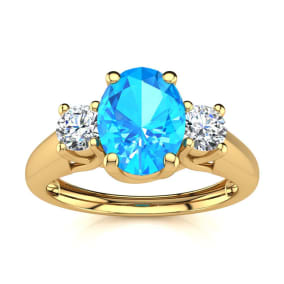 1 1/5 Carat Oval Shape Blue Topaz and Two Diamond Ring In 14 Karat Yellow Gold
